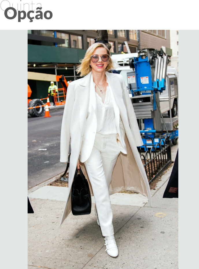 Uma mulher veste conjunto branco com blazer e casaco longo