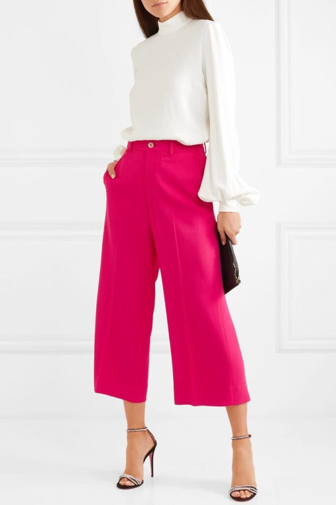 mulher usa calça pantacourt pink com sapato metalizado